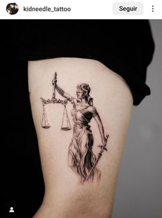 a lady justice tattoo on the back of a woman's lower thigh, holding a scale