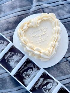 a heart shaped cake sitting on top of a white plate next to three pictures and an album