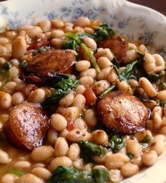 a white bowl filled with beans and spinach