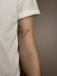 a small butterfly tattoo on the left arm