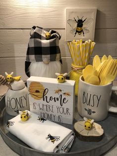 a table topped with mugs filled with yellow and white items next to a sign that says honey is where your honey is