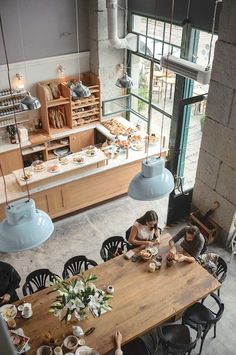 a woman sitting at a table in a bakery