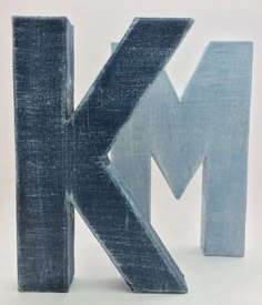 the letter k is made out of wood and has been painted blue with white letters