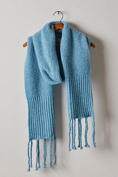 a blue knitted scarf hanging on a wall