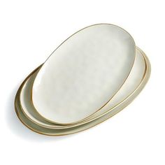 three white and gold plates stacked on top of each other