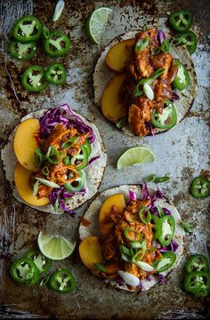 three tacos with chicken, cabbage and peppers on a baking sheet next to sliced jalapenos