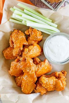 chicken wings and celery sticks with ranch dip on the side, ready to be eaten