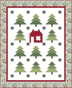 a quilt with trees and a house in the middle, on top of it is a red