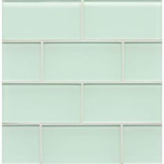 a light green brick wall with white tiles on the bottom and one in the middle