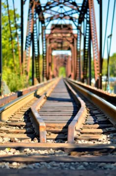 an old train track going under a bridge