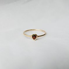 This Garnet Heart Ring brings love with you wherever you go. Show someone you love that you always have them in your heart. A great gift ring! Details: 14k gold (available in yellow, rose or white gold)Garnet heart measures about 3mm Free Shipping on Domestic Orders Materials: Garnet, 14k gold Need your ring bigger tha Garnet Heart Ring, Heart-shaped 14k Gold Ruby Promise Ring, 14k Gold Heart-shaped Ruby Ring For Promise, Yellow Gold Heart Birthstone Promise Ring, 14k Gold Heart Ring With Birthstone For Promise, 14k Gold Solitaire Heart Ring As Gift, Yellow Gold Stackable Heart Cut Rings For Promise, 14k Gold Heart-shaped Solitaire Ring, Yellow Gold Solitaire Heart Ring For Valentine's Day