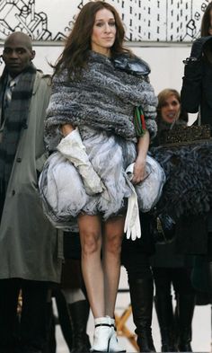 a woman is walking down the street in fur