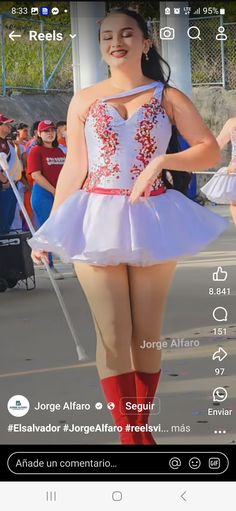 a woman in a white dress and red socks is standing on the street with her hands behind her back