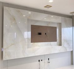 a bathroom with a large mirror and two faucets on the wall next to it