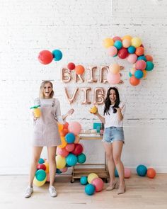 two young women standing in front of balloons