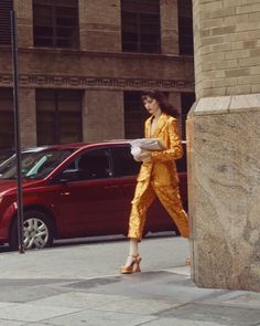 a woman in yellow is walking down the street