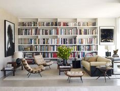 a living room filled with lots of furniture and bookshelves full of books on shelves