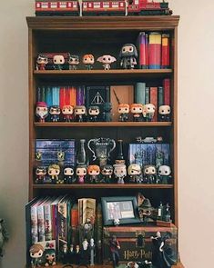 a bookshelf filled with lots of harry potter figurines on top of wooden shelves