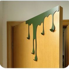 a wooden door with green paint dripping from it