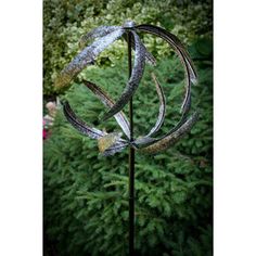 a metal sculpture in the middle of a garden