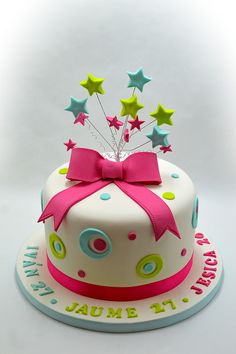 a birthday cake decorated with stars and a pink bow on top that says it's annual