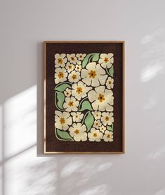 a painting hanging on the wall with white and yellow flowers painted on it's side