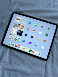 an ipad sitting on top of a bed covered in app icon sticker decals