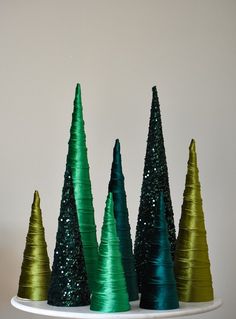 small green and gold christmas trees sitting on top of a white plate