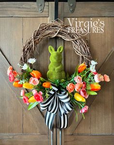 a wreath with a green bunny sitting on top of it next to a wooden door