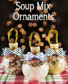 two jars filled with food sitting on top of a red and white table cloth next to a christmas tree