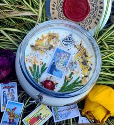 a candle surrounded by cards and flowers on the ground next to some other items that have been placed around it