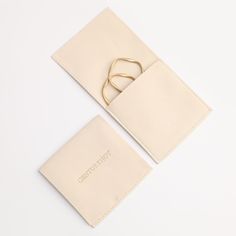 a pair of gold scissors sitting on top of a piece of white paper next to an envelope