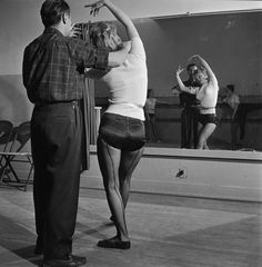 a man and woman dancing in front of a mirror