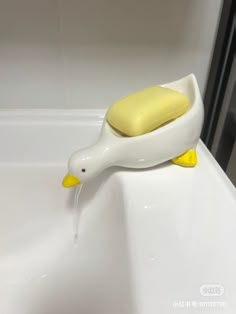 a yellow and white duck shaped soap dispenser