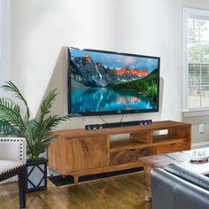 a flat screen tv sitting on top of a wooden stand