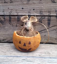 a stuffed mouse in a pumpkin shaped basket