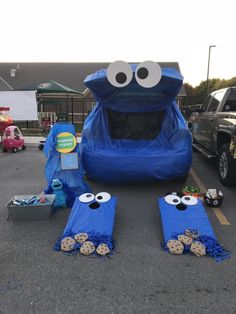 an inflatable blue car with eyes and googly eyes sitting on the ground