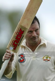 a man holding a bat in his hand and looking off to the side with an angry look on his face