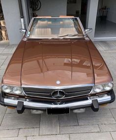 a brown car parked in front of a garage