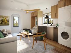 a living room filled with furniture and a washing machine in the corner next to a kitchen