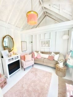 a living room filled with furniture and a pink rug on top of a white floor