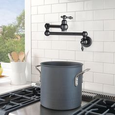 a large pot is sitting on the stove in front of an oven with two faucets