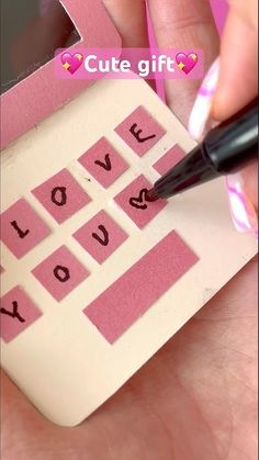 someone is writing on a piece of paper that says i love you