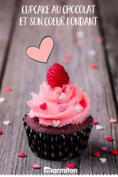 a chocolate cupcake with pink frosting and a raspberry on top that says cupcake au chocolat et son coeur fondant