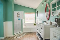 a bathroom with green walls and white fixtures, including a bathtub in the corner