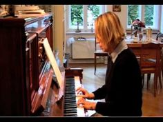 a woman is playing the piano in her living room