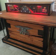 a wooden chest with an eagle emblem on it and red lights in the top shelf