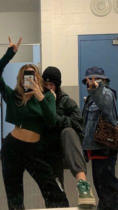 two people taking pictures in the mirror with their cell phones while one person takes a selfie