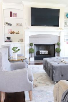 a living room filled with furniture and a flat screen tv mounted above the fire place