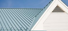 the top of a white building with a blue sky in the backgroung